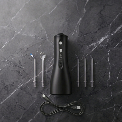 Black dental water flosser with various nozzles on a dark marble surface